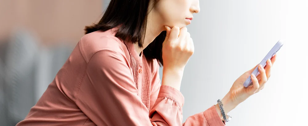 スマホを見つめて一人で確かめようとする女性